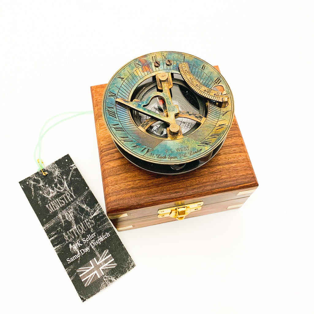 Peut inclure: Un compas de soleil en laiton dans une boîte en bois. Le compas a une finition irisée bleue et verte. La boîte a un loquet en laiton.