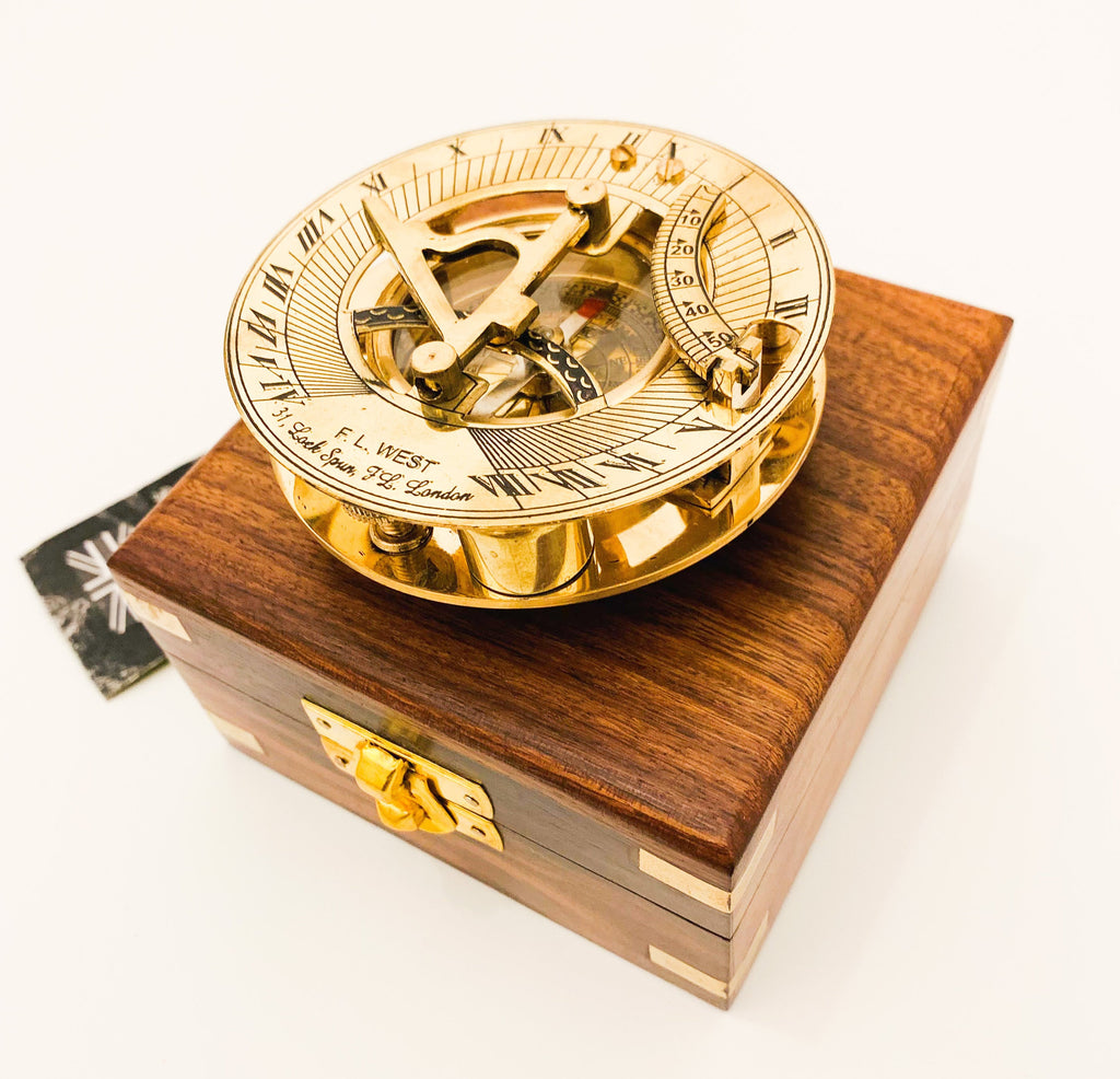 May include: A brass sundial with a compass and a wooden box. The sundial has Roman numerals and the text "F.L. WEST 31.8. Loth. Squa. 32. London".