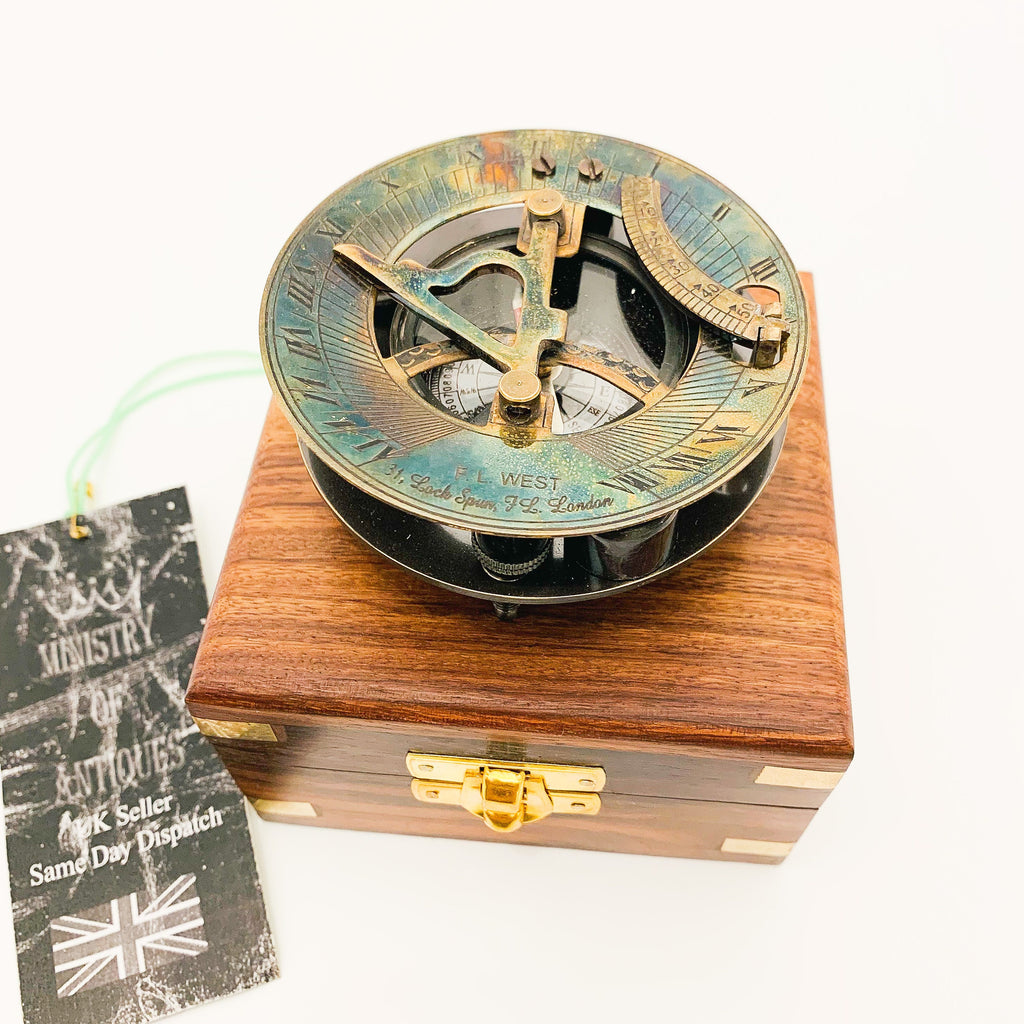Peut inclure: Un cadran solaire en laiton avec une boussole et une boîte en bois. Le cadran solaire a une aiguille de boussole, un couvercle en verre transparent et un anneau en laiton avec des chiffres romains. La boîte est en bois foncé avec un loquet en laiton.