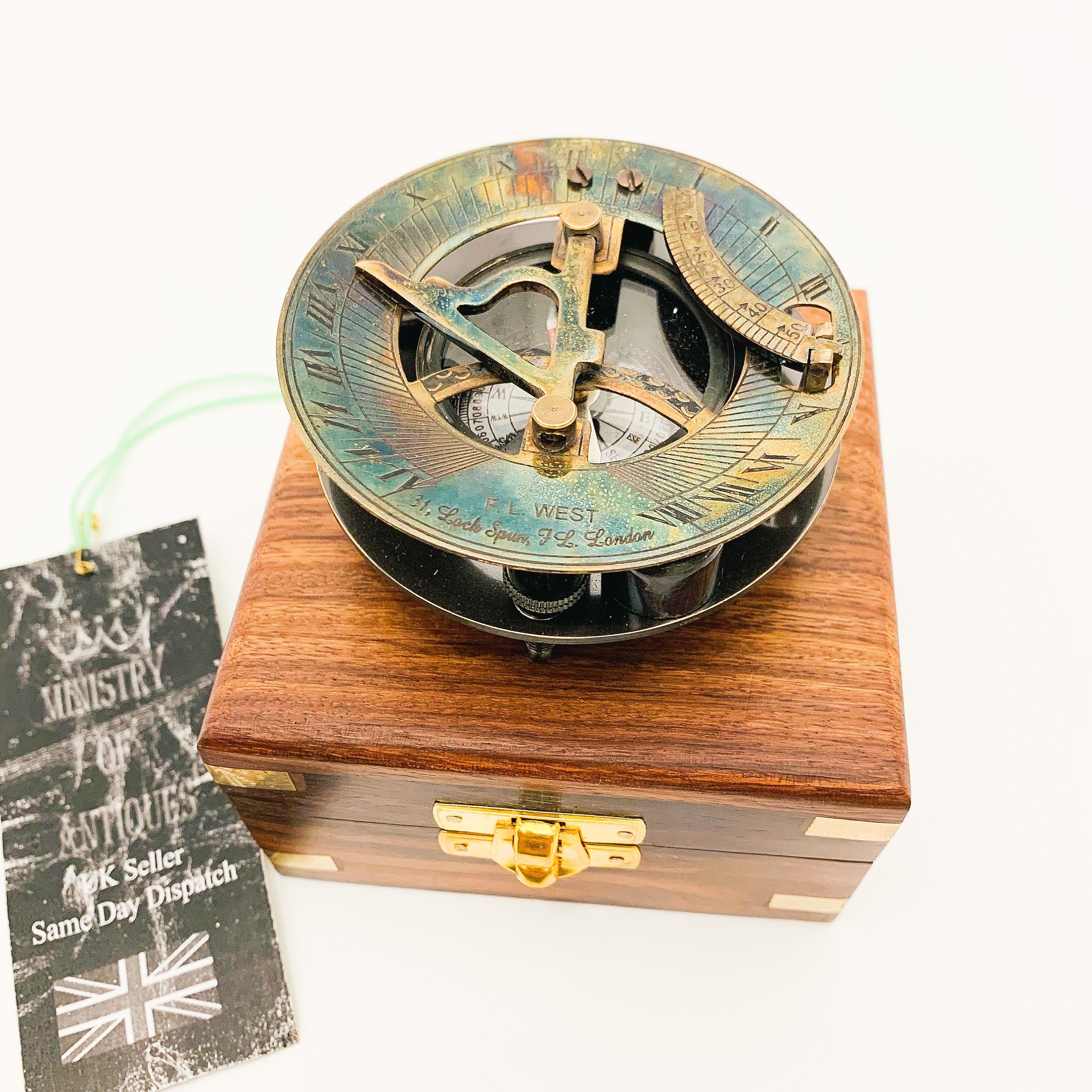 Peut inclure: Un cadran solaire en laiton avec une boussole et une boîte en bois. Le cadran solaire a une aiguille de boussole, un couvercle en verre transparent et un anneau en laiton avec des chiffres romains. La boîte est en bois foncé avec un loquet en laiton.