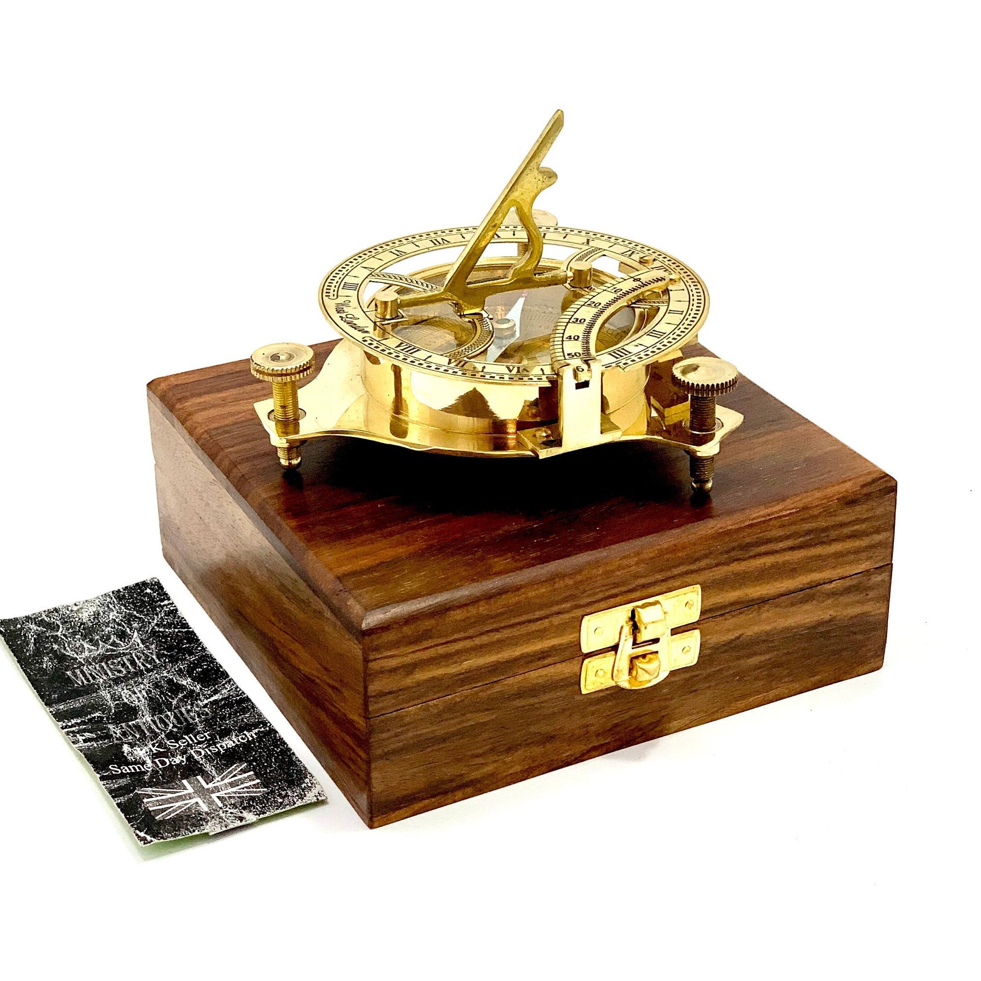 May include: A brass sundial with a compass and a wooden box. The sundial has a clear glass cover and a brass gnomon. The box is made of dark wood with a brass latch.
