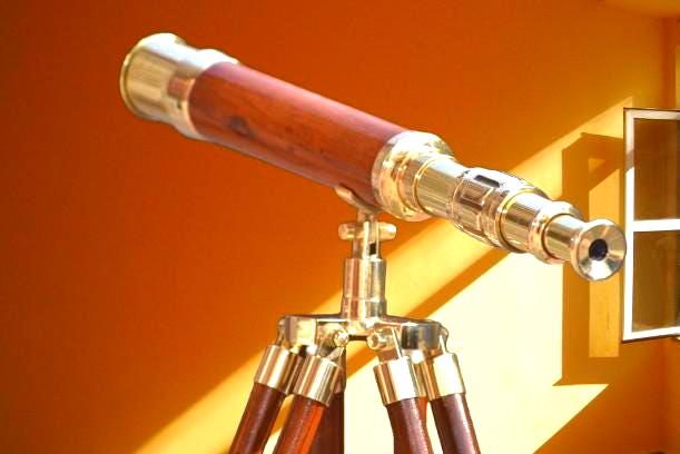 May include: A classic telescope with a wooden barrel and brass detailing. It is mounted on a brass tripod with wooden legs. The design has a vintage nautical or scientific feel, reminiscent of exploration.