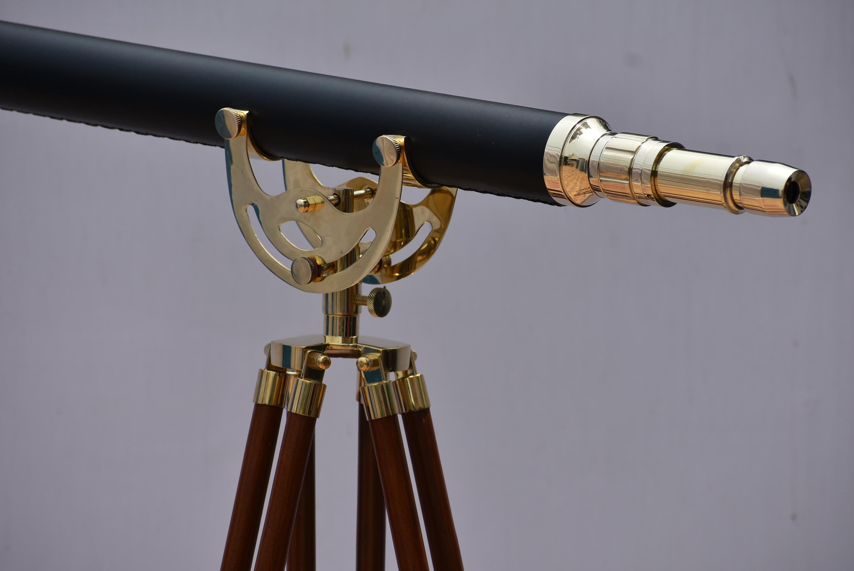 May include: A vintage-style telescope with a black barrel and brass accents. The telescope is mounted on a wooden tripod with brass fittings. The design evokes a classic nautical or scientific aesthetic.